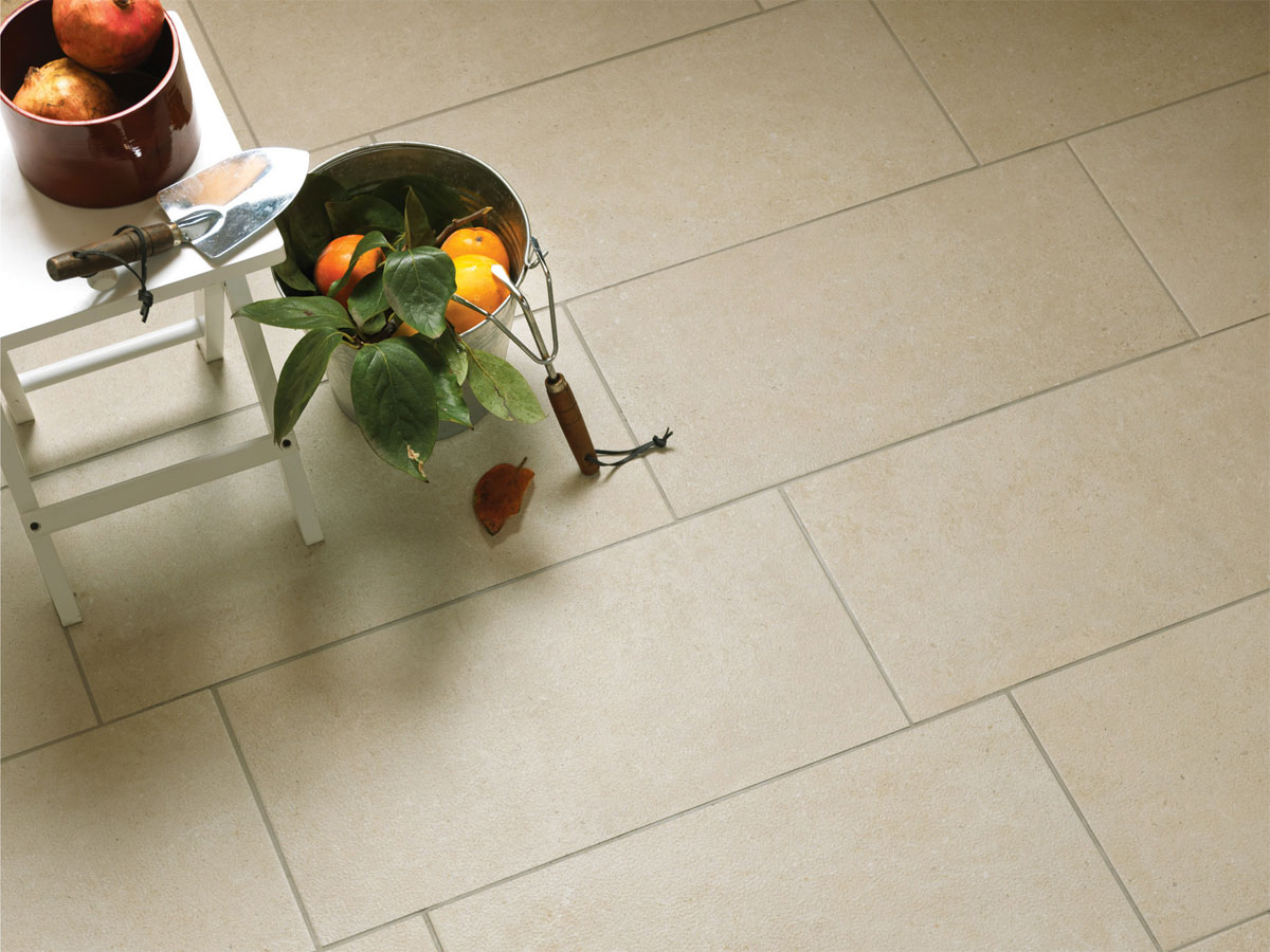 gardening tools and fruit positioned a beige tiled floor