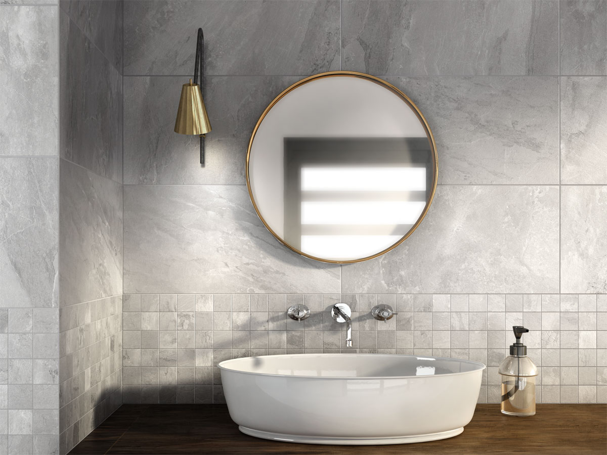 modern freestanding basin and circular mirror on a grey tiled wall