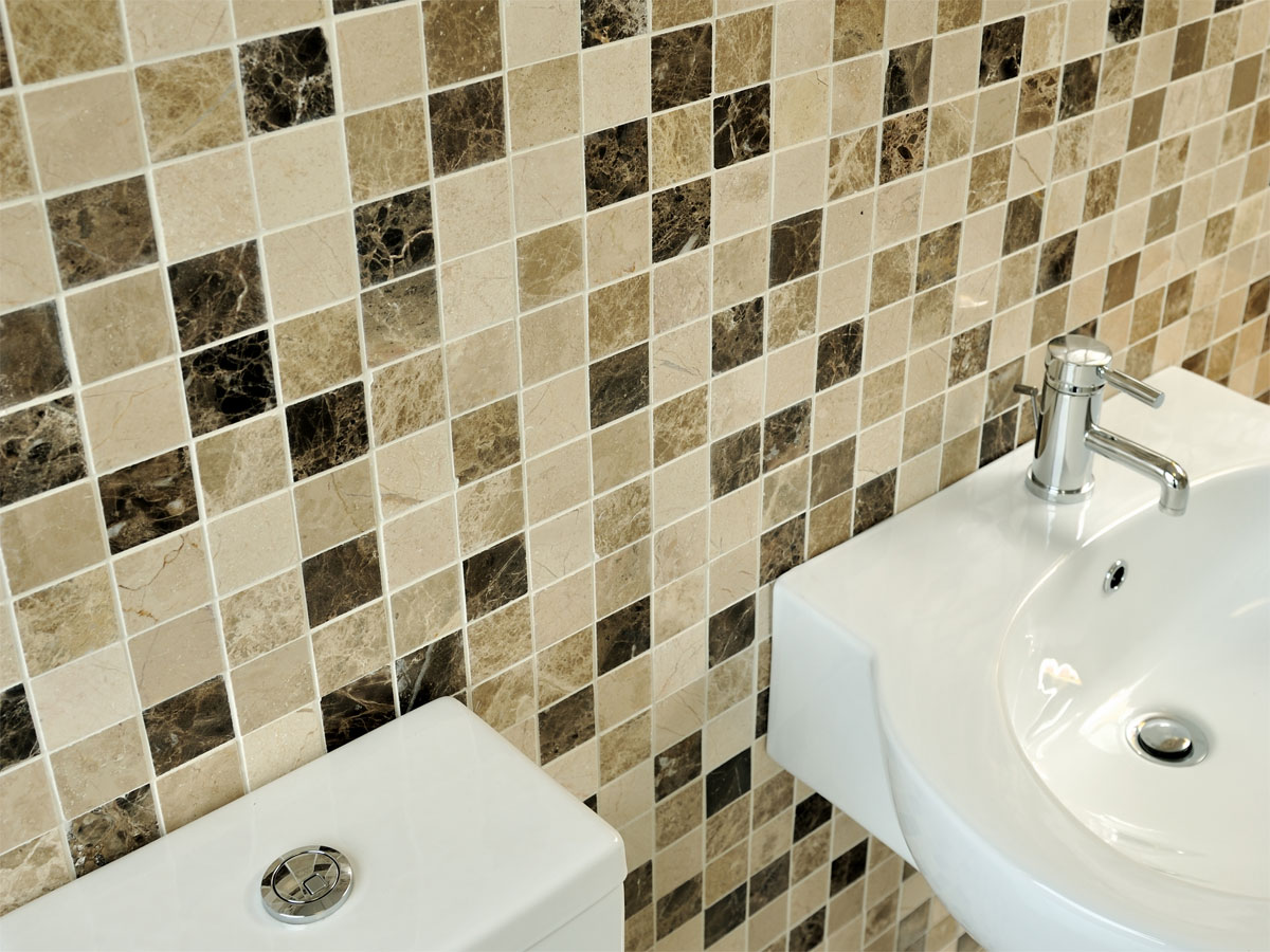 a marble mosaic wall with a basin & toilet in front