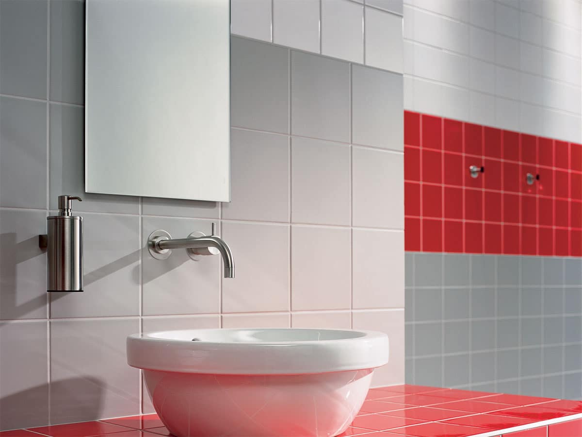 functional bathroom with vibrant red tiles as a border
