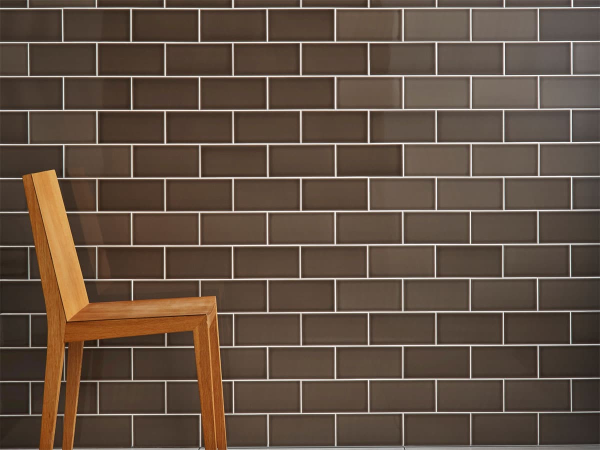 tiled wall in a pleasing tile with a single dinning room chair in front