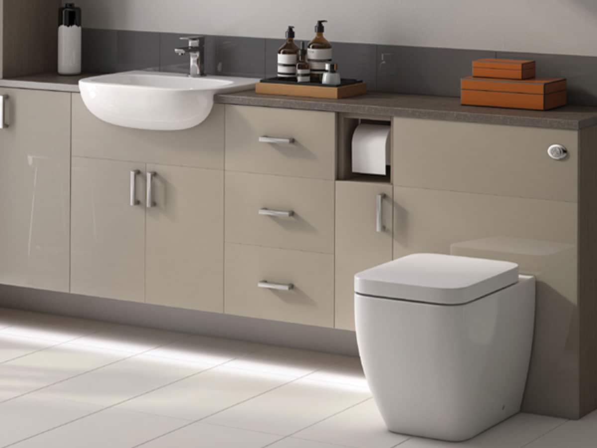 a run of champagne bathroom furniture with a grey worktop
