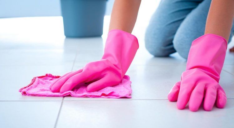 tiles being cleaned with a pink cloth and pink rubber gloves