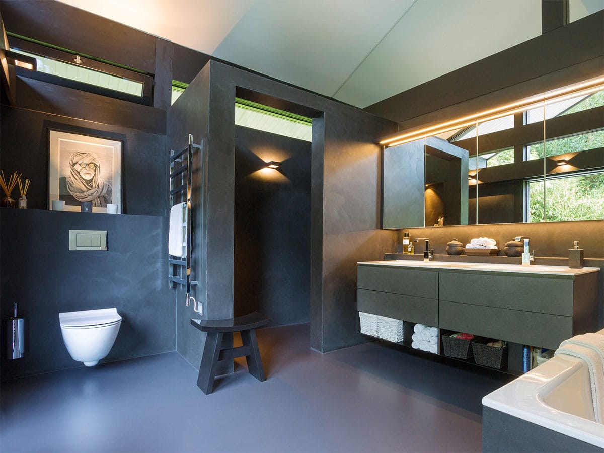 modern concrete themed bathroom with a private walk in showerroom and his and hers basins