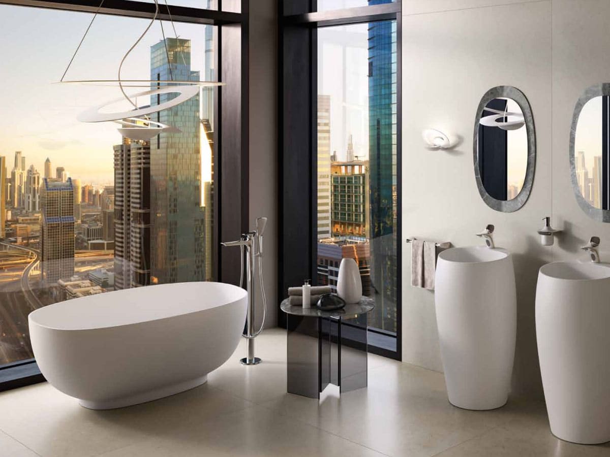 modern apartment bathroom with freestanding bath and column basins